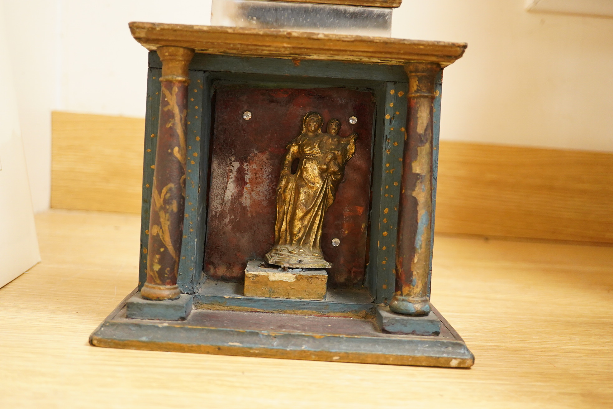 An early 19th century painted pine cross with mirrored front and a cast gilt metal statue of Mary and child, 78cm high